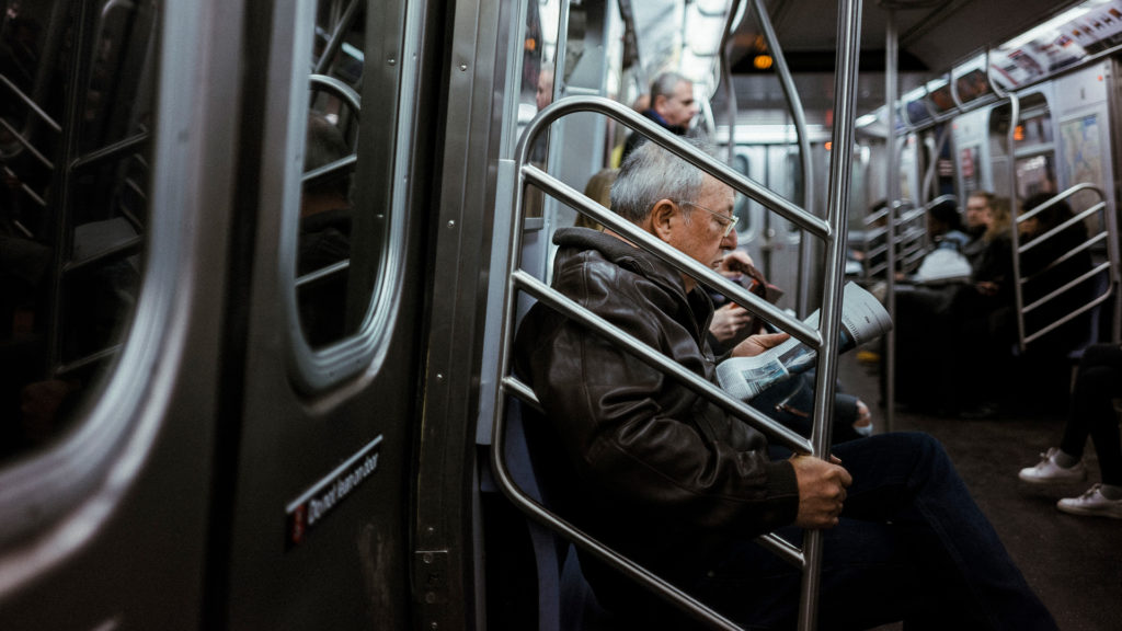 Older man sitting on the NYC Subway.