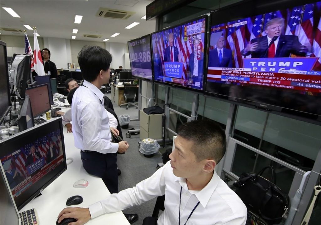 Two Japanese stock traders watch President Trump's speech on TV on Election Night 2020