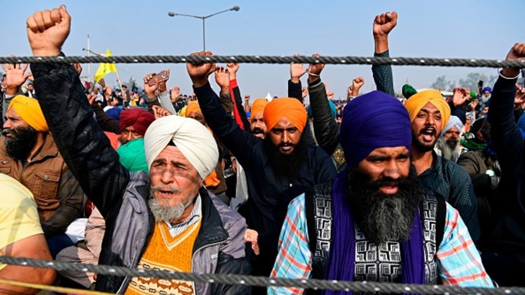 Sikh protesters in India hold up their fists.