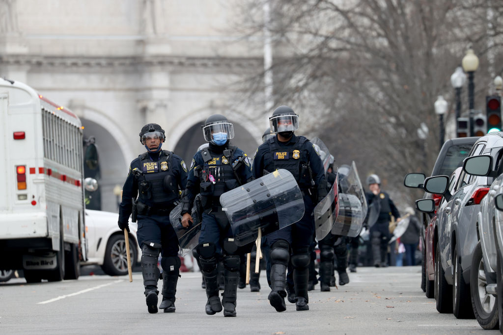 Police in riot gear and shields near Washington Capitol.