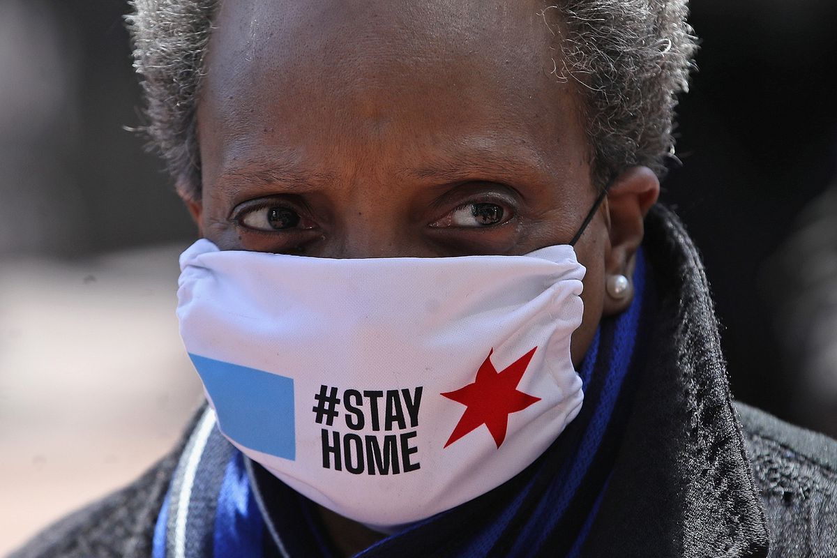 The photograph shows Chicago mayor Lori Lightfoot wearing a mask with the hashtag Stay at Home.
