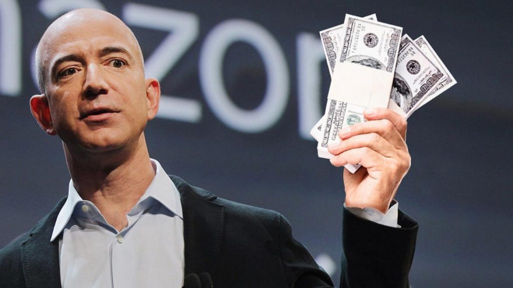 Amazon founder Jeff Bezos holds up a lot of cash.