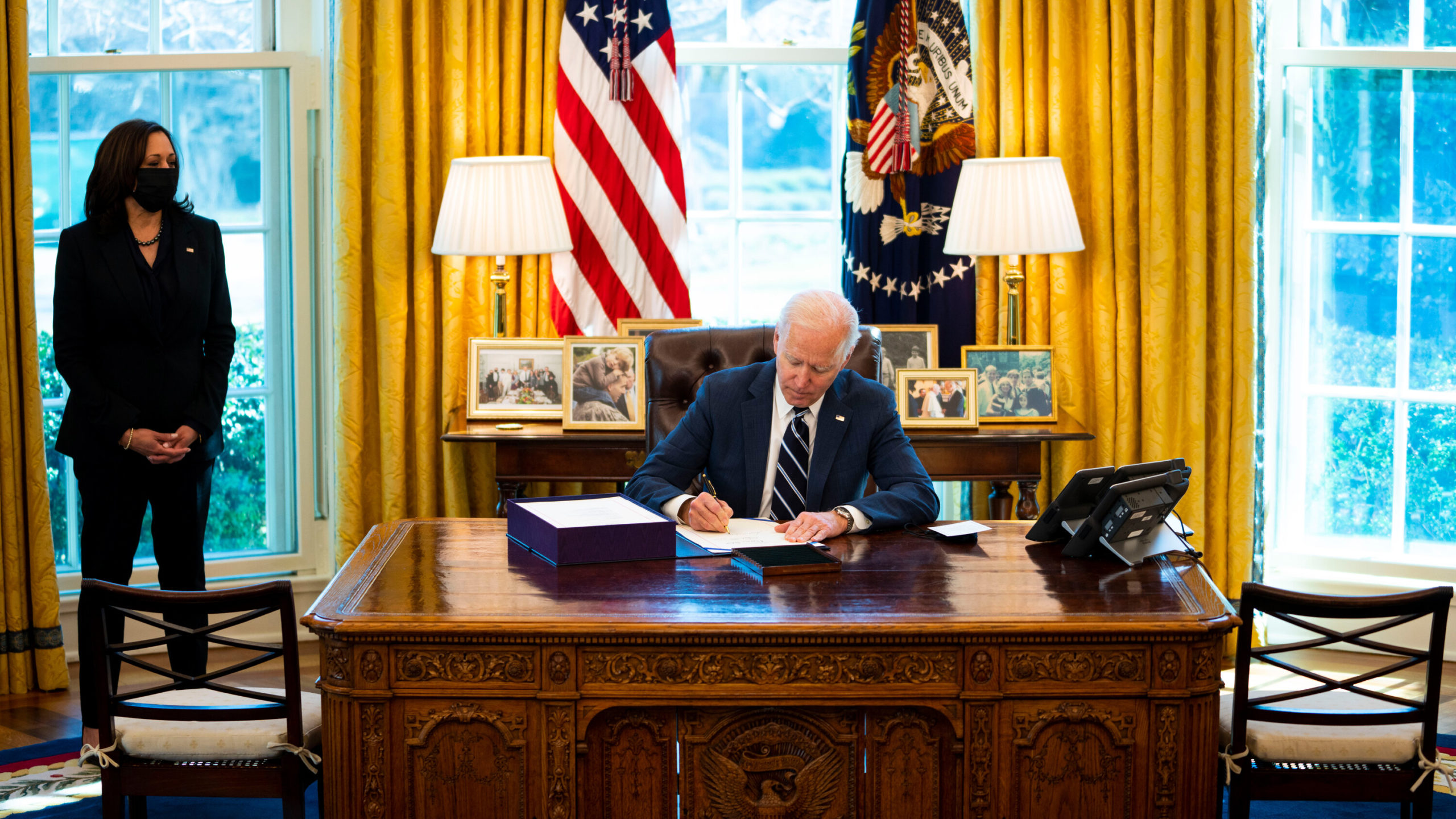 The photo shows President Joe Biden signing the stimulus bill on Thursday, March 11, in the Oval Office, as Vice President Kamala Harris looks on.