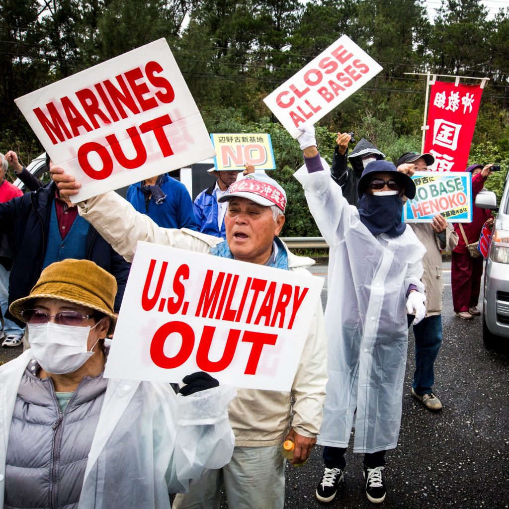 The photo shows protesters in Okinawa at the site of construction of a new U.S. military base