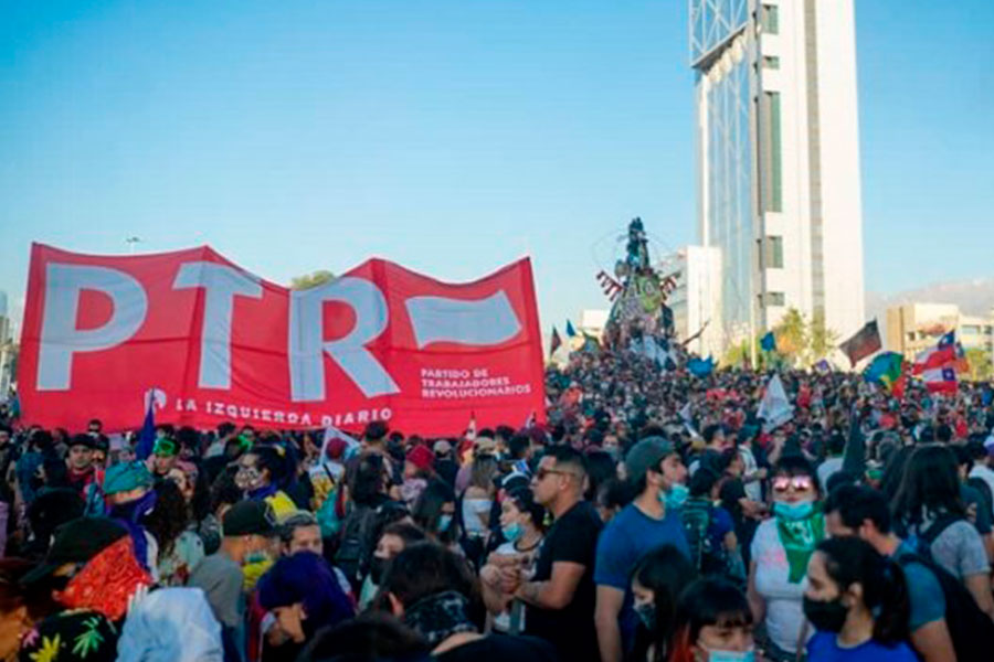A crowd of people in Chile, a big red banner says "PTR."