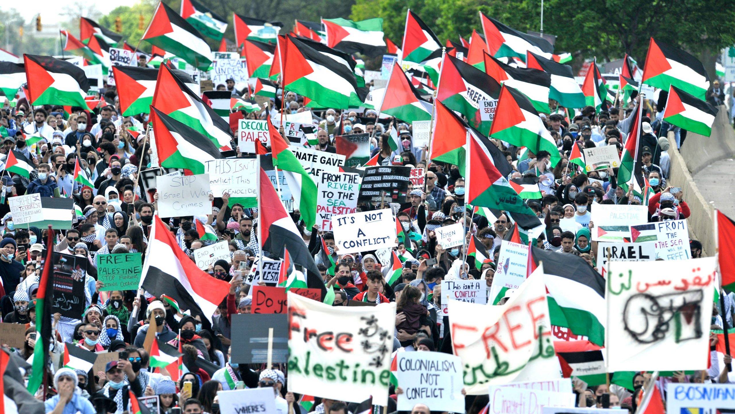 A crowd of protesters in Dearborn, Michigan protest Biden's visit, they hold Palestinian flags