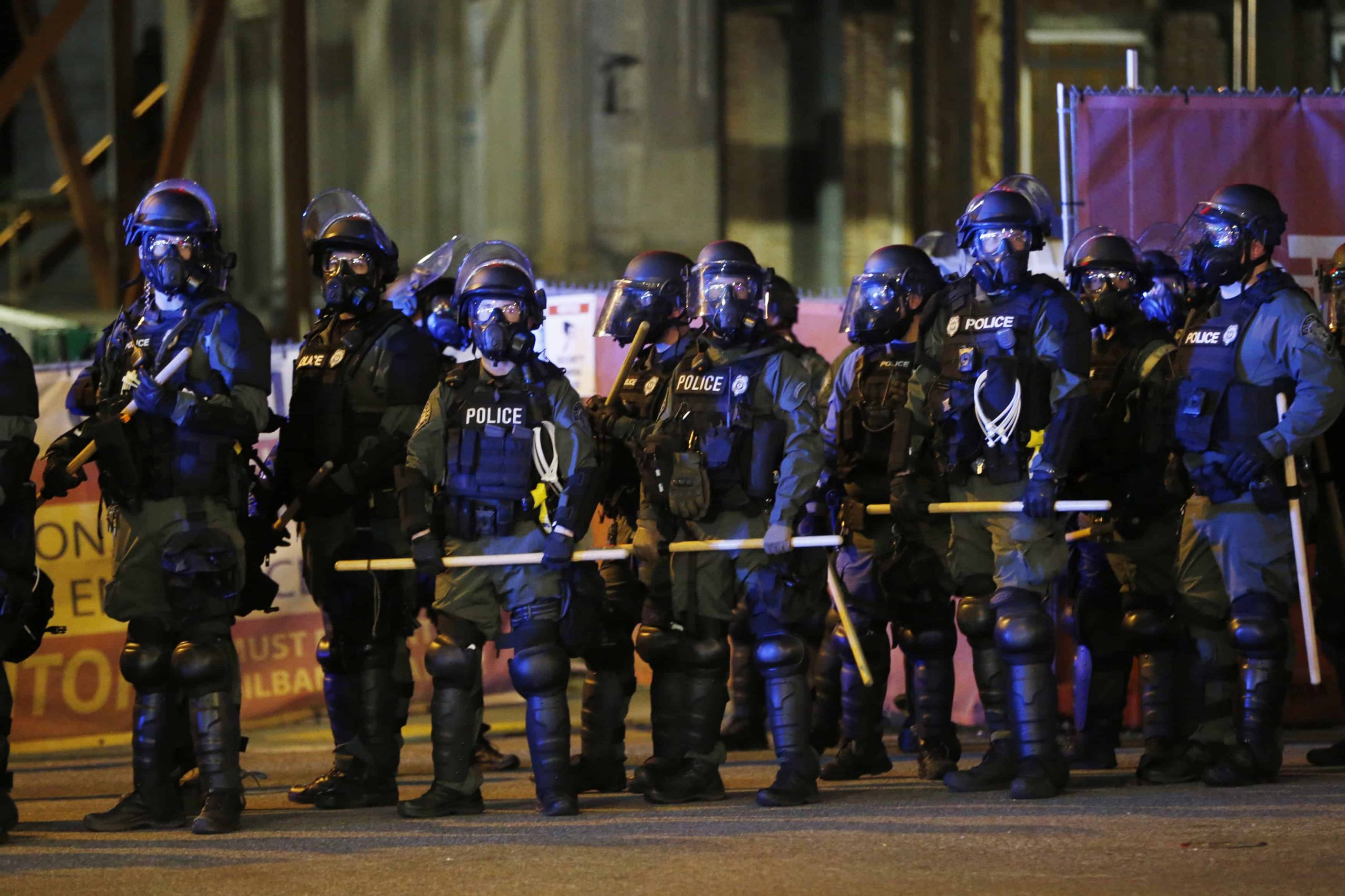 A line of cops wearing riot gear