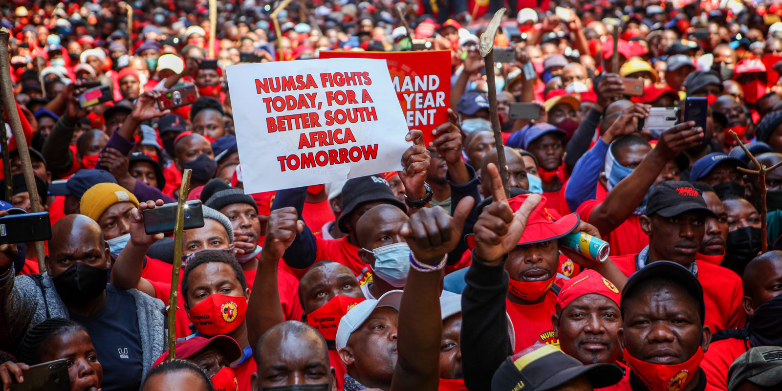A sea of South African NUMSA workers wearing red t-shirts. A sign says "NUMSA fights today for a better South Africa tomorrow."