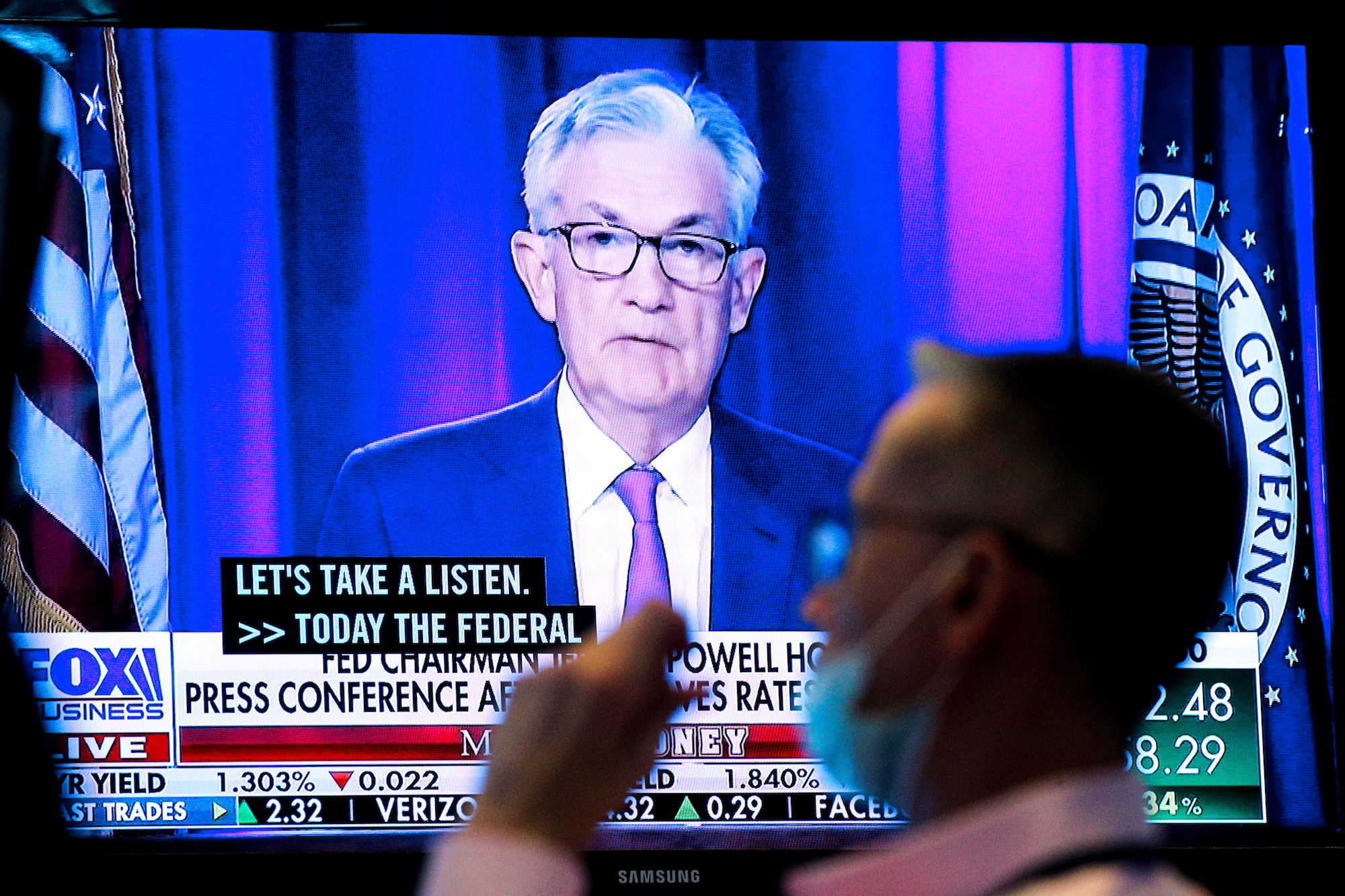 A screen displays a statement by Federal Reserve Chair Jerome Powell as a trader works on the floor of the New York Stock Exchange in New York City, U.S., September 22, 2021.