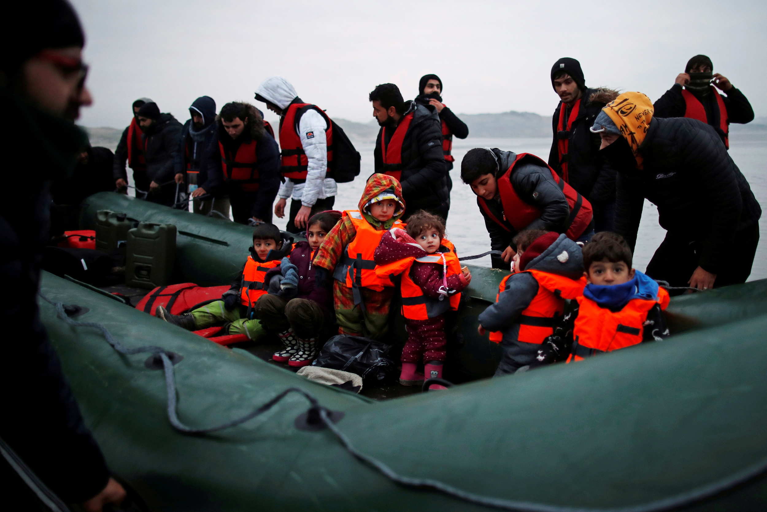 A group of more than 40 migrants with children get on an inflatable dinghy, as they leave the coast of northern France to cross the English Channel, near Wimereux, France, November 24, 2021.