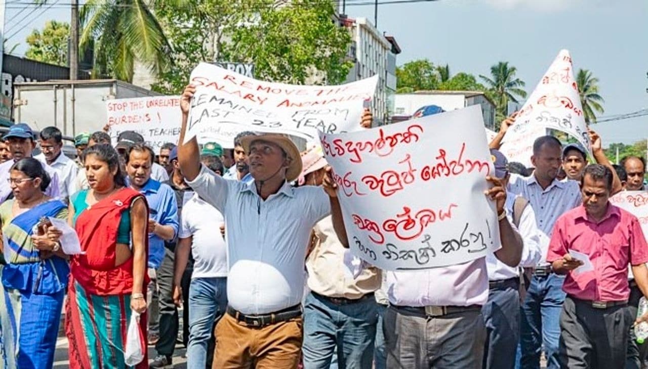 Sri Lankan teachers protesting and holding signs