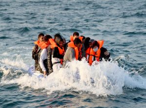 This photo shows migrants in orange vests during a crisis moment at sea.