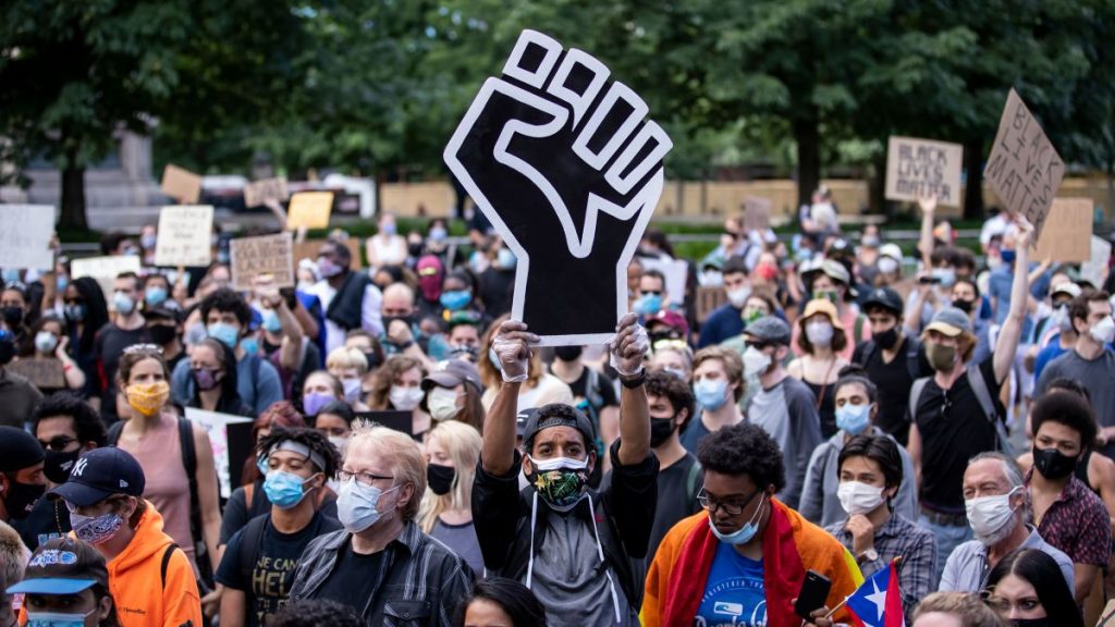 A protester holds a large Black Power fist in the middle of a crowd gathered in New York on June 14, 2020.