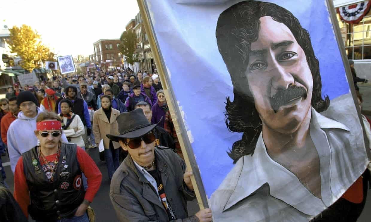 Marchers carry a banner depicting Leonard Peltier during a march for the National Day of Mourning in Plymouth, Massachusetts, on 22 November 2001