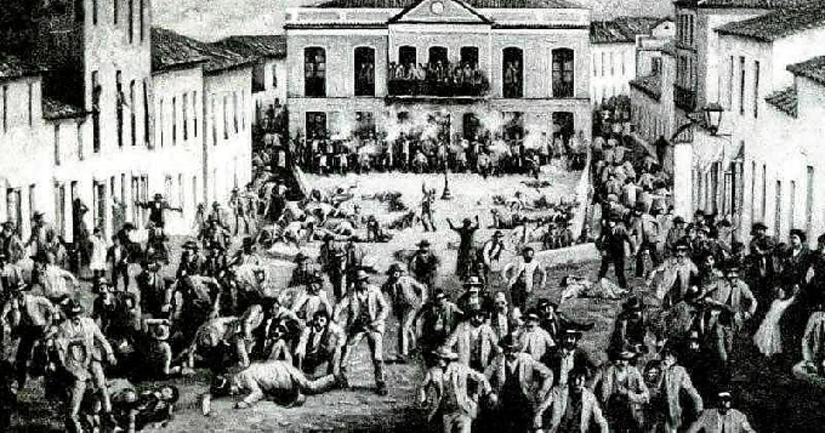 Black and white photo of a town square with many people dying on the ground.