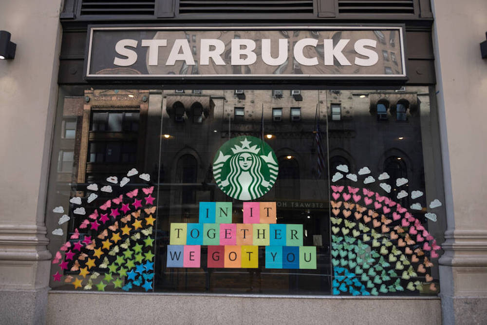 A Starbucks storefront covered in rainbow post-it notes