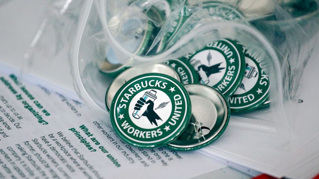 Starbucks Workers United pins on top of some papers.