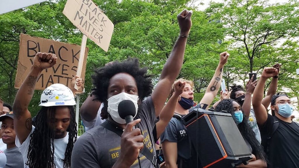 Tristan Taylor and other BLM protersters marching with their fists in the air