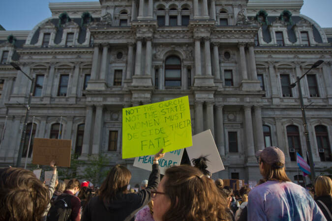 Protesters in front of Philadelphia City Hall with a sign that reads Not the church, not the state, women must decide their fate.