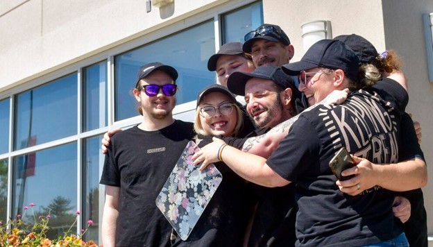 Several workers hugging in front of a Chipotle Store