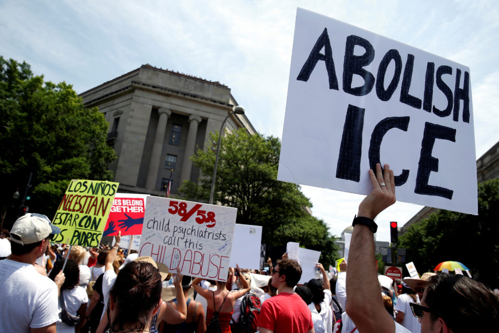 An immigration activist holds up a sign calling for the abolishment of ICE, U.S. Immigration and Customs Enforcement, during rally to protest the Trump Administration's immigration policy outside the Department of Justice in Washington, U.S., June 30, 2018.