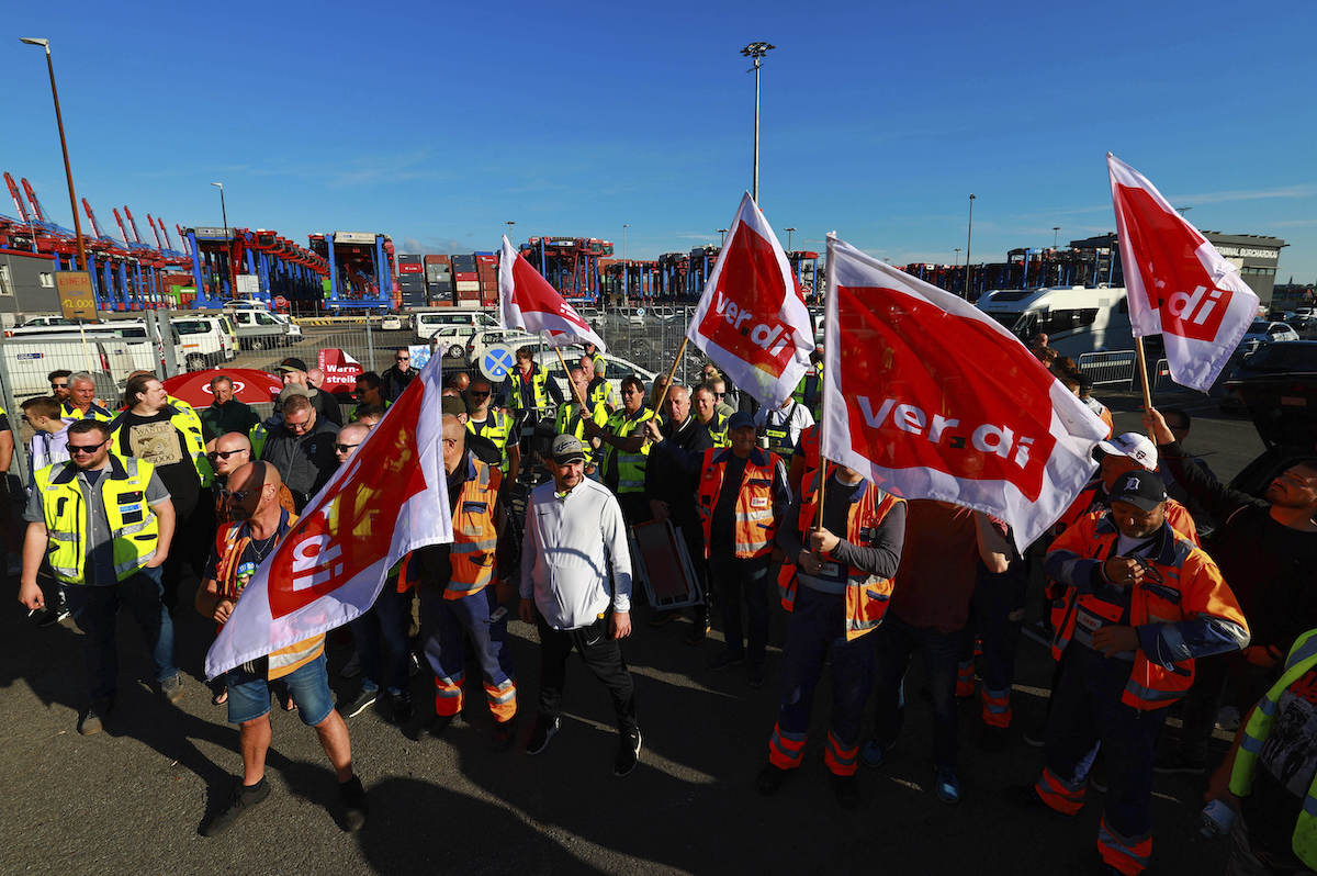 Workers with Ver.di flags protest during a warning strike in front of the Container Terminal Burchardkai of Hamburger Hafen und Logistik AG on July 14, 2022.