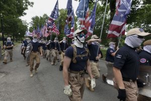 Members of far-right group Patriot front march while carrying US flags