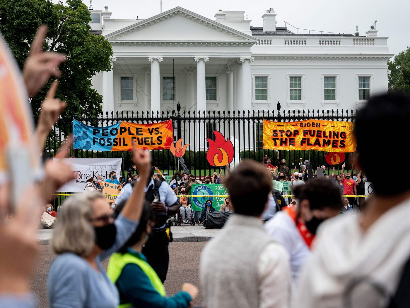 Demonstrators chant in front of the White House during a climate march on October 12, 2021.