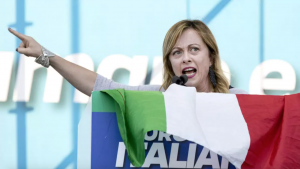 Italian far-right leader Giorgia Meloni gives a speech, an Italian flag covers the podium