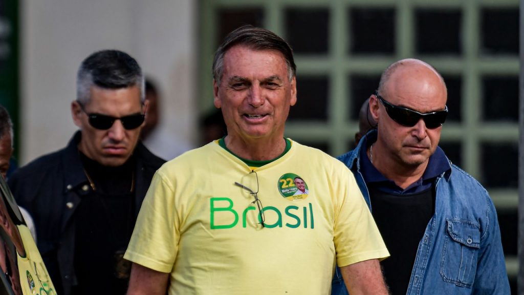 Jair Bolsonaro pictured on election day. Wearing a yellow Brazil shirt and smiling.