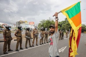 A man holds a Sri Lankan national flag during a protest outside the Parliament complex in Colombo, Sri Lanka