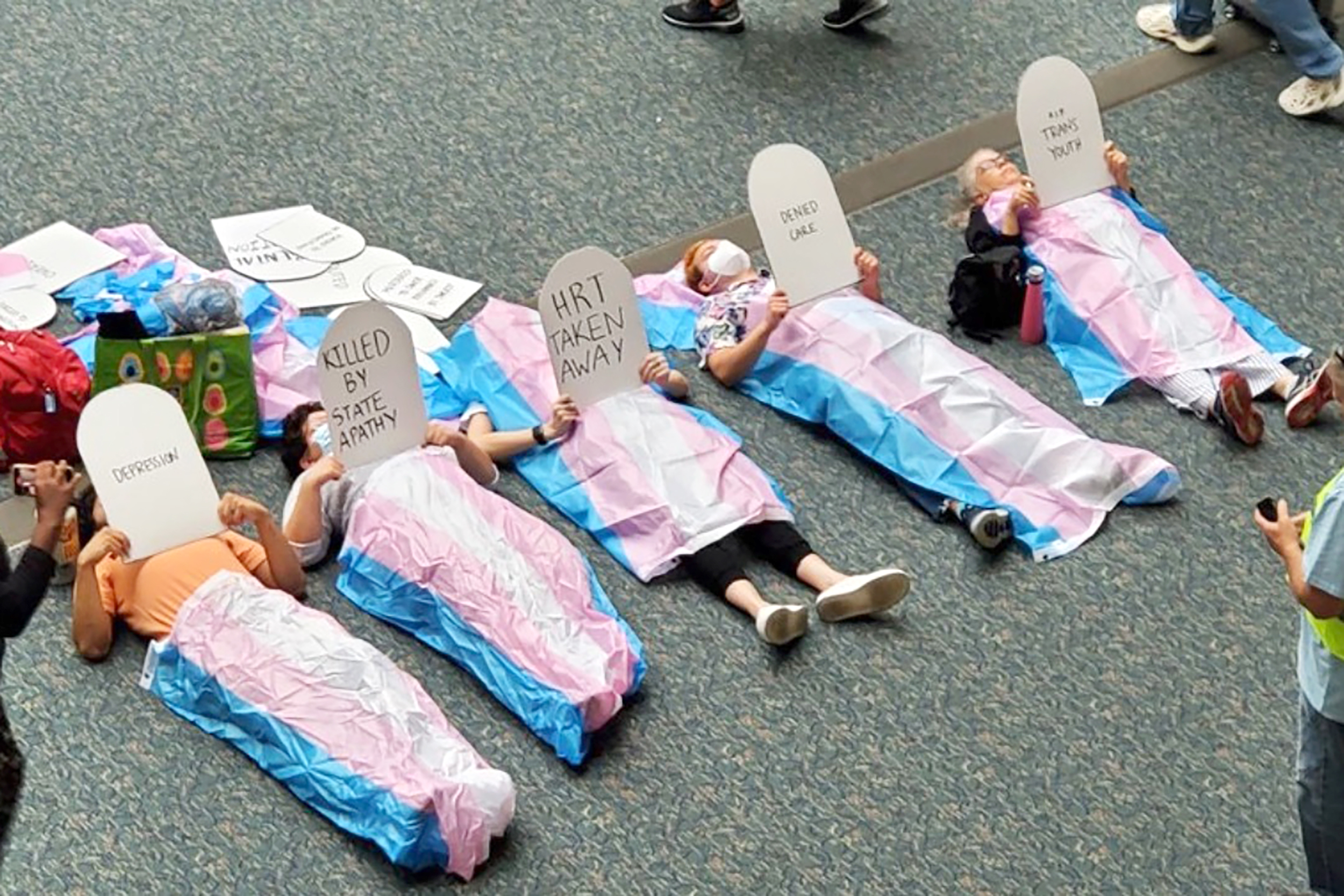 Protesters stage a "die-in" in the lobby of the Orlando International Airport on Oct. 28, 2022