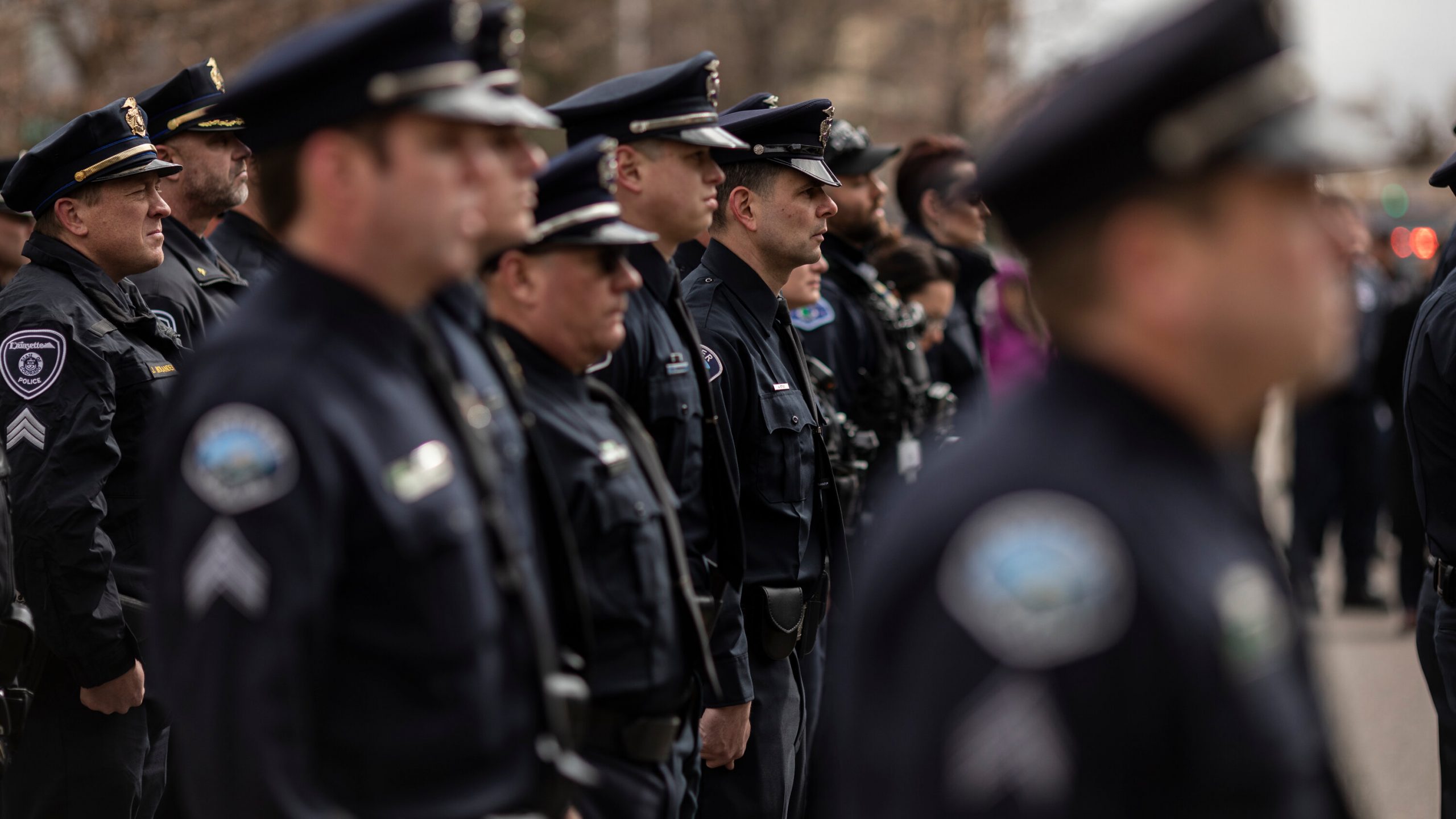Several lines of police officers stand outdoors.