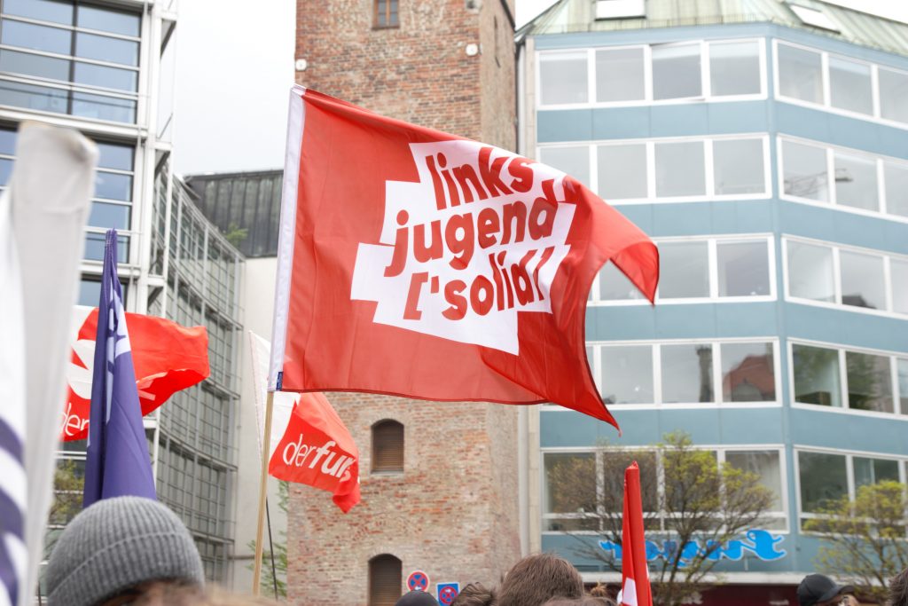 A flag says "Linksjugend-Solid," the youth organization of Germany's Die Linke party.