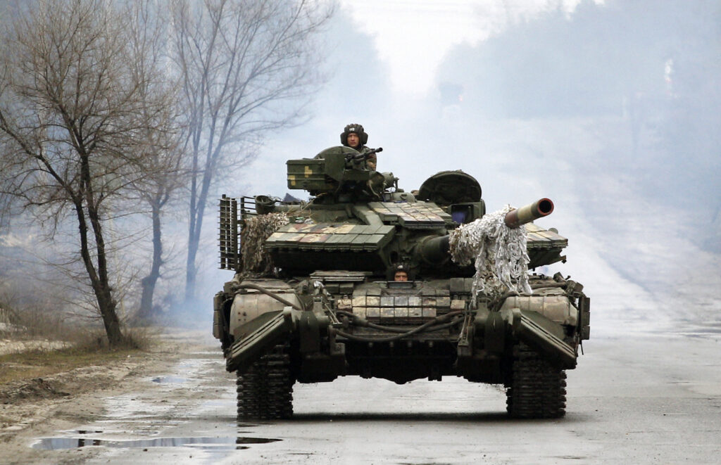 Ukrainian servicemen ride on tanks towards the front line with Russian forces in the Lugansk region of Ukraine on February 25, 2022
