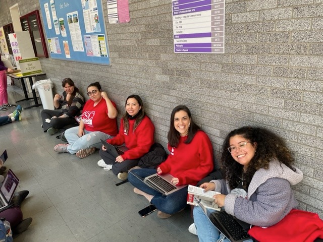 City College writing professors sit in a hallway at City College to protest cuts to pay in writing courses.