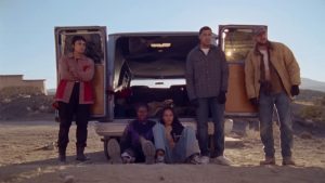 Five young people stand in front of a car in a dessert in a scene from the movie "How to Blow Up a Pipeline."