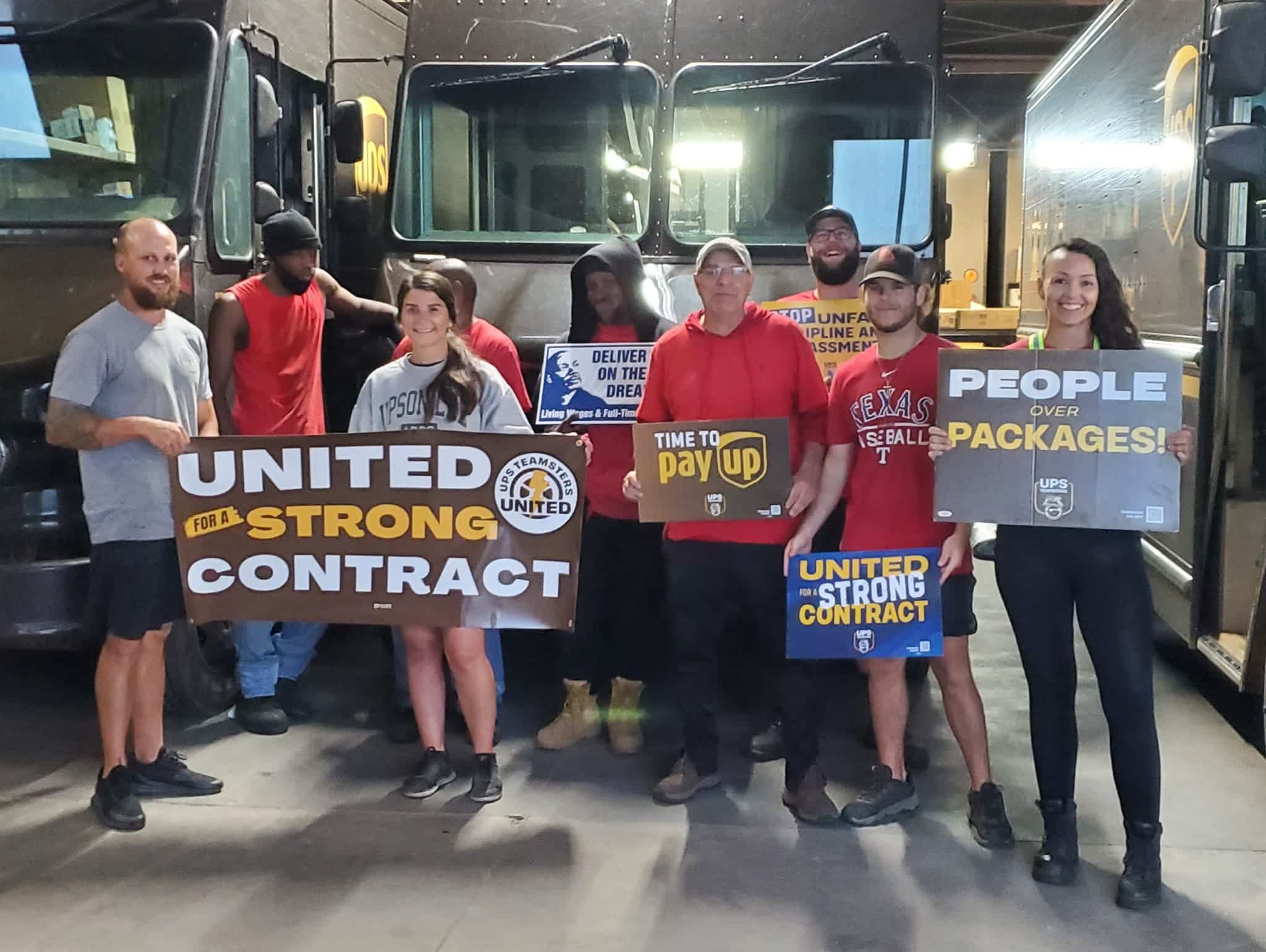 UPS workers hold signs at a rally that say "United for a Strong Contract."