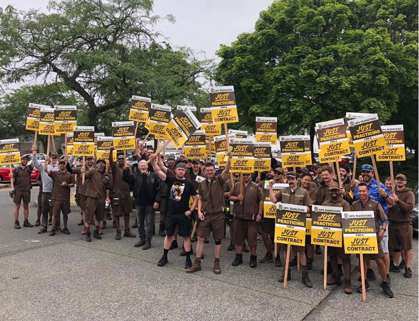 UPS workers at a rally, wearing brown uniforms.