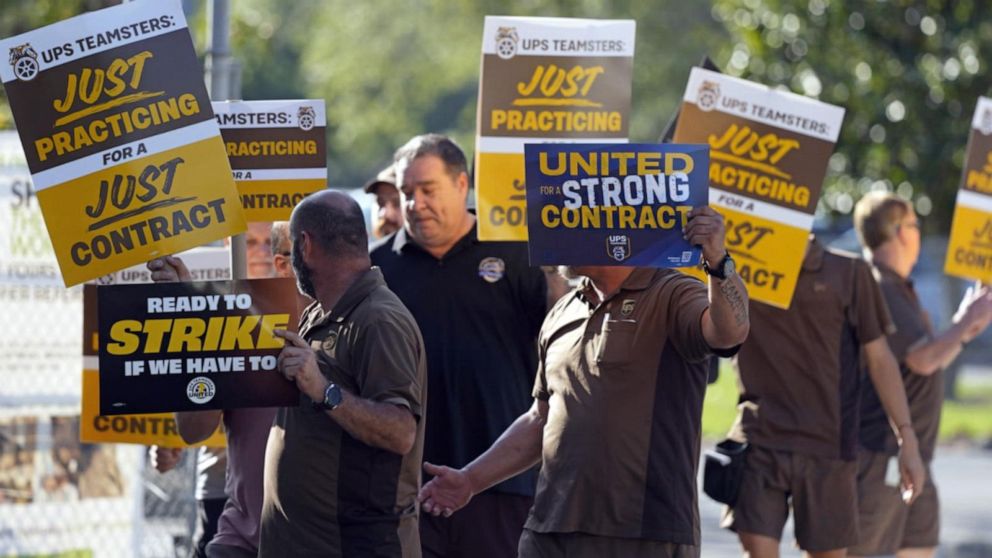 UPS workers at a rally carrying signs that read "United for a strong contract."