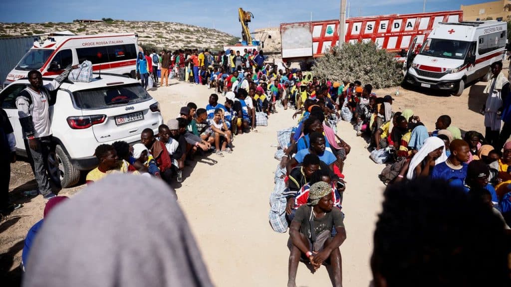 Migrants from Northern Africa sit in lines on the Italian island of Lampedusa.