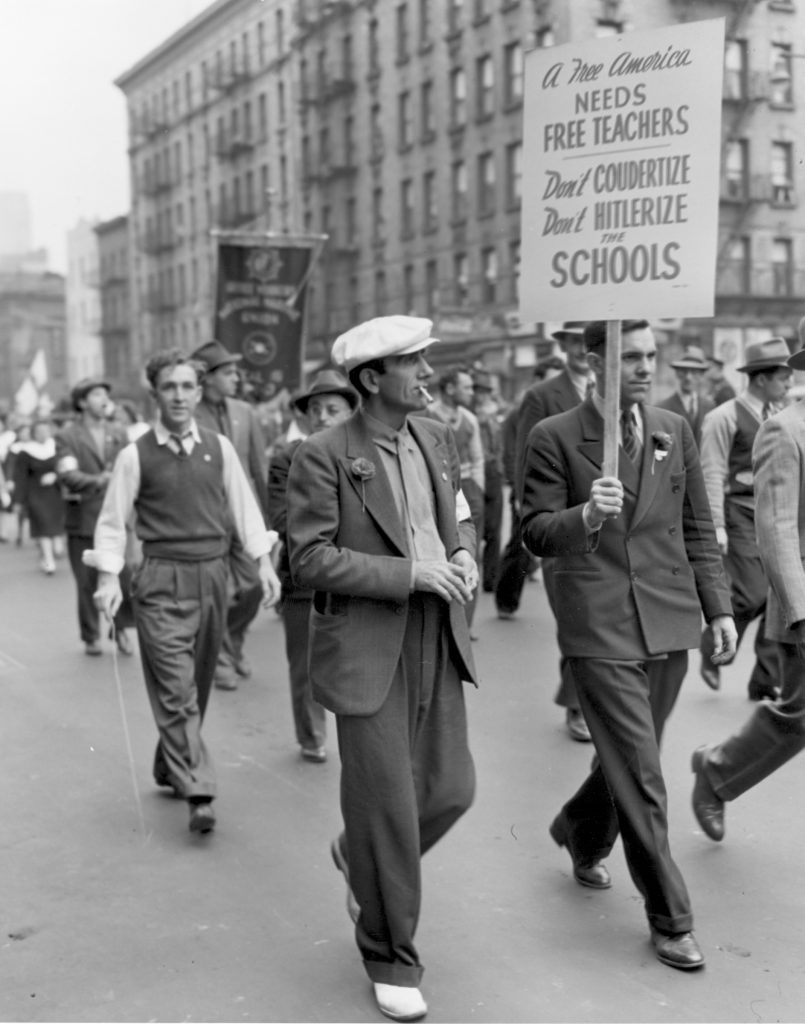 1941 police surveillance photo from May Day parade. Sign says "don't Coudertize, Don't Hiterlize the Schools"