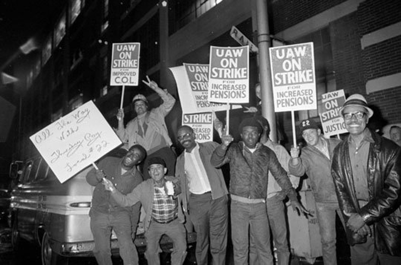 Black UAW workers, a black-and-white image, holding signs that say "UAW ON STRIKE."