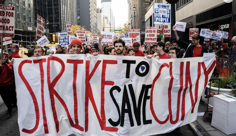 CUNY workers at a demonstration hold a banner that reads "STRIKE TO SAVE CUNY."