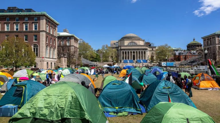 Tents on a lawn in front of university buildings